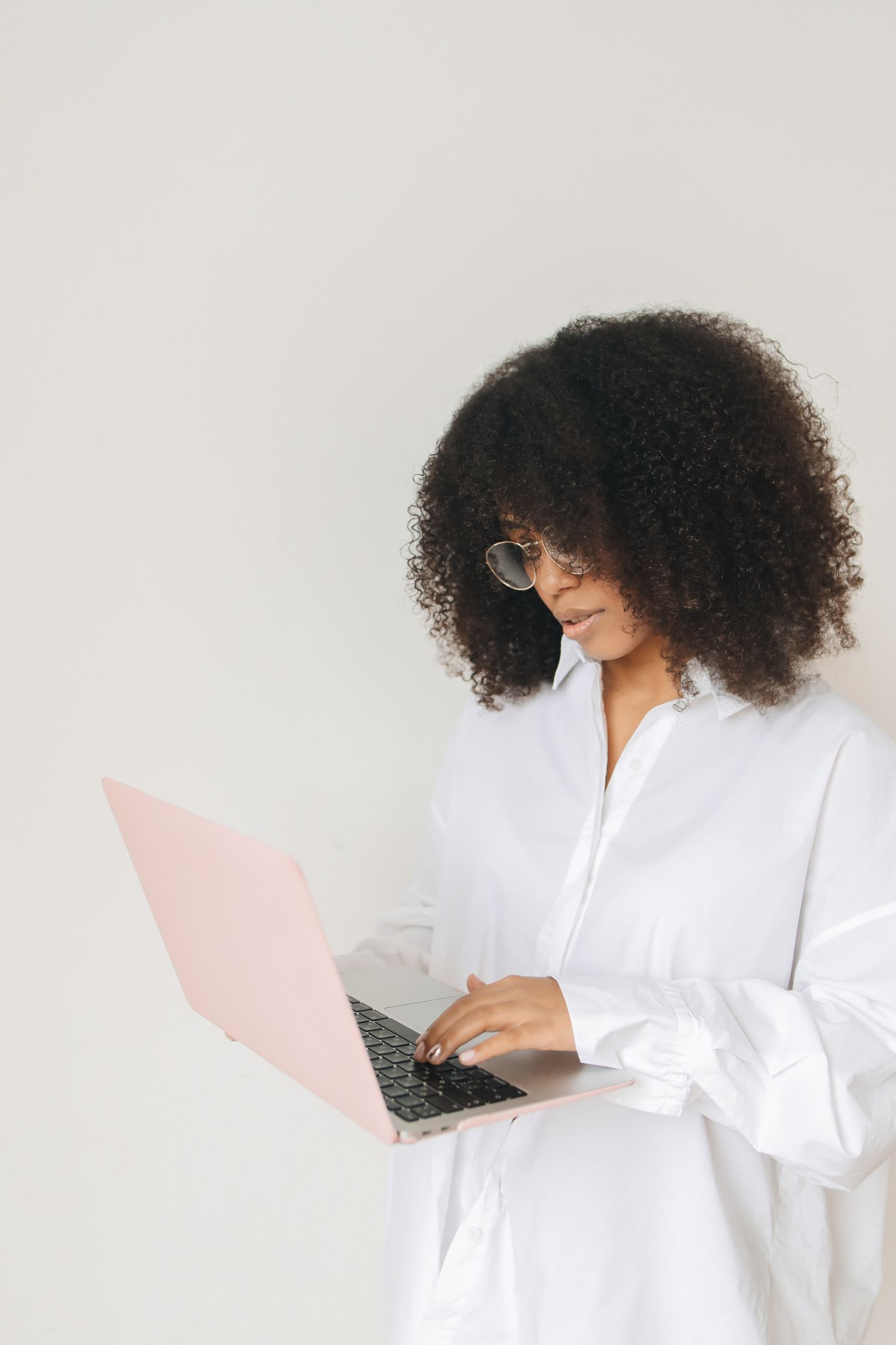 A female business owner wearing a white shirt working on her laptop